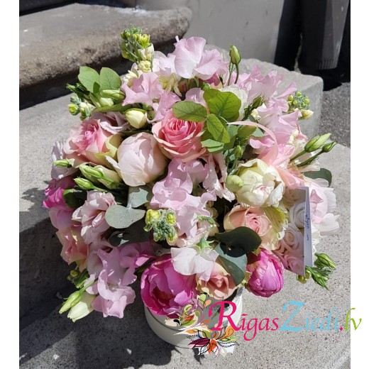 A flower arrangement in a box with matthiolas, roses and peonies